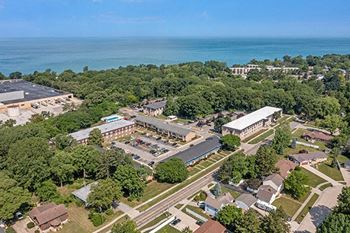 an aerial view of the campus with the ocean in the background